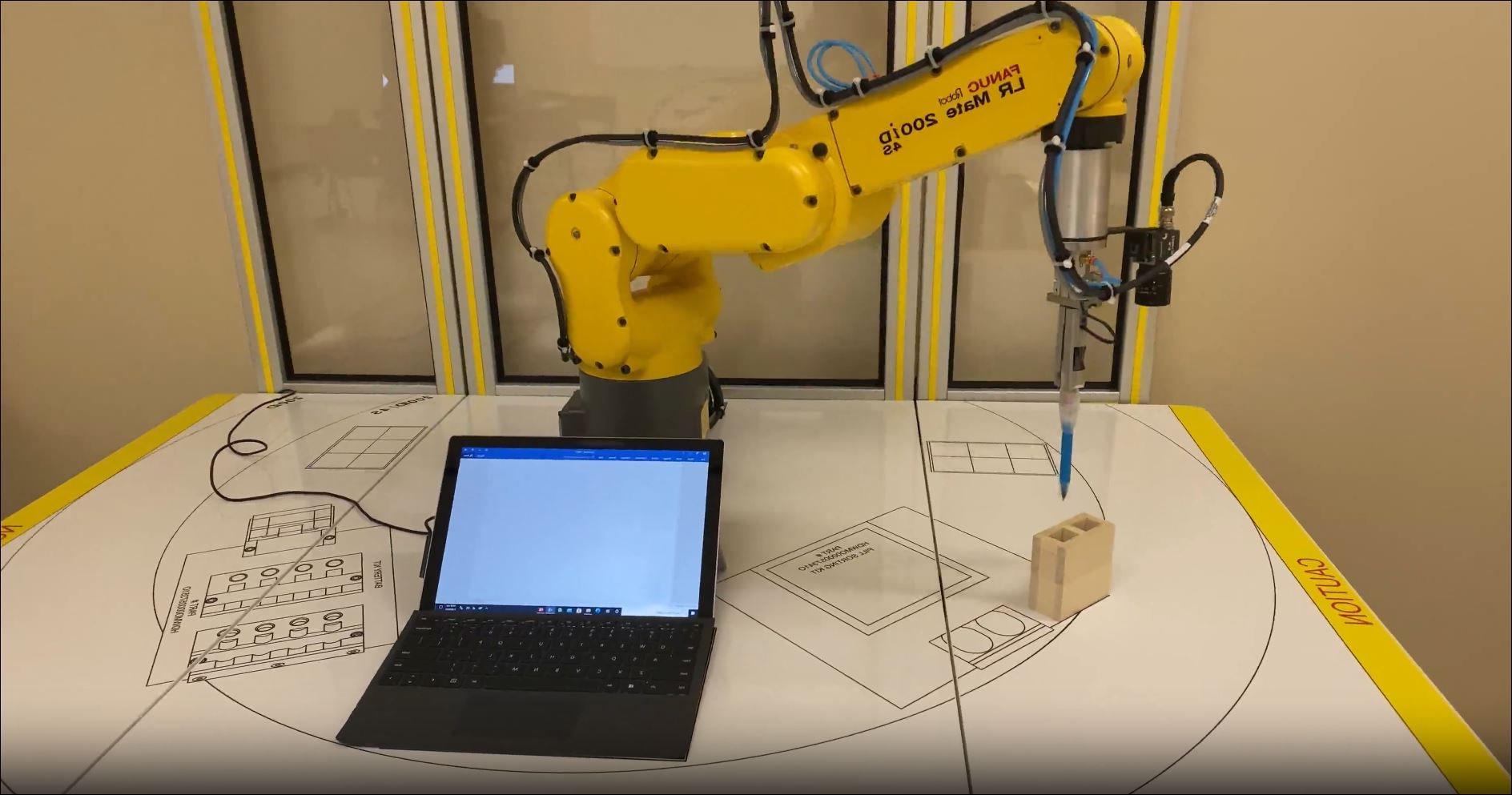 Advanced Manufacturing yellow robot with laptop computer